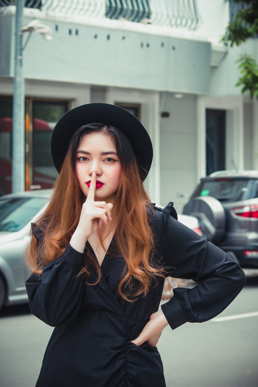 a woman in black dress wearing black hat
