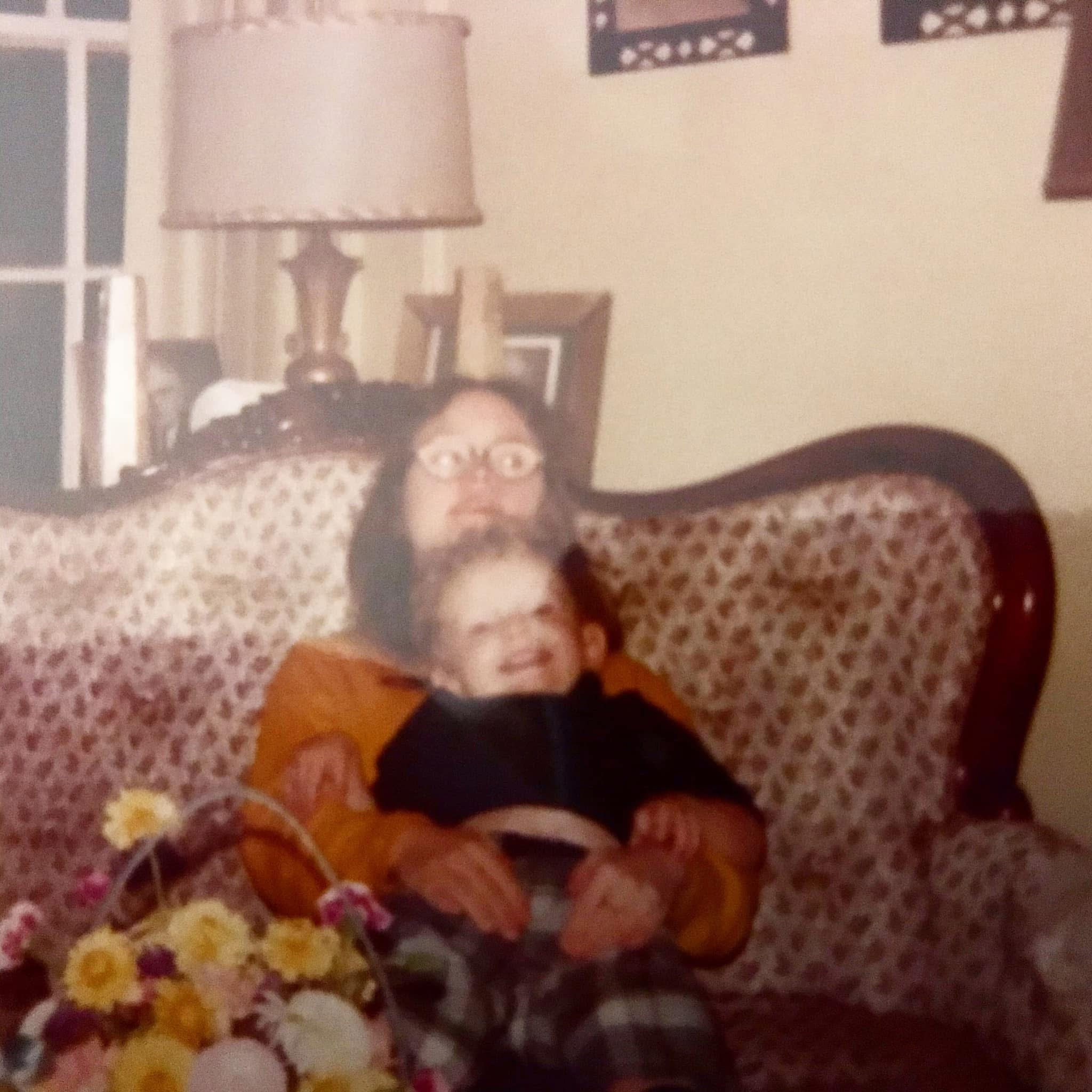 old photo with a woma with down syndrome holding her toddle nephew